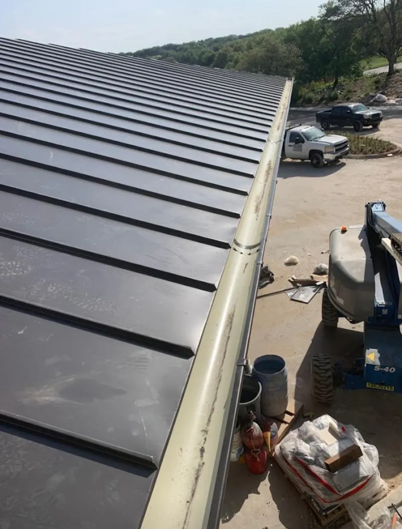 Standing seam panel and gutter detail on a metal roofing jobsite in Lemoore